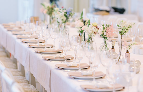 Table setting with floral arrangements and small gifts for a wedding rehearsal dinner