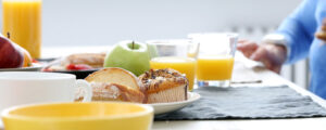 table spread of fruits, orange juice and various pastries of office breakfast